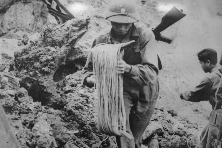 Vietnamese soldier laying cable by hand