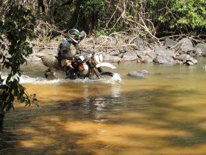riding across a jungle river in Laos