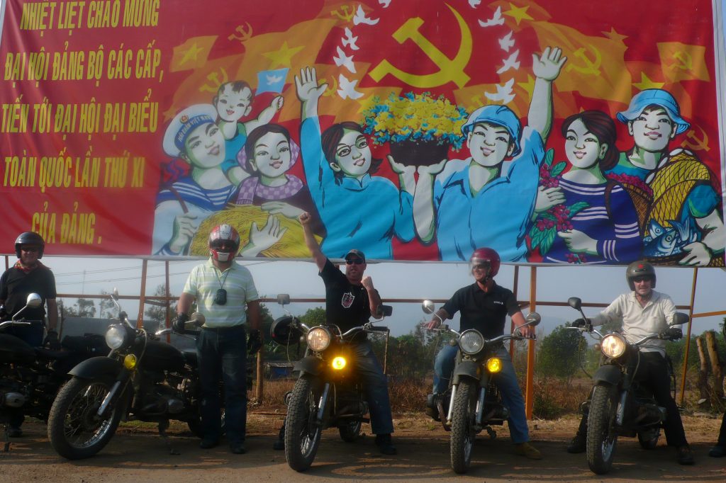 group photo by a poster - these are common throughout Vietnam