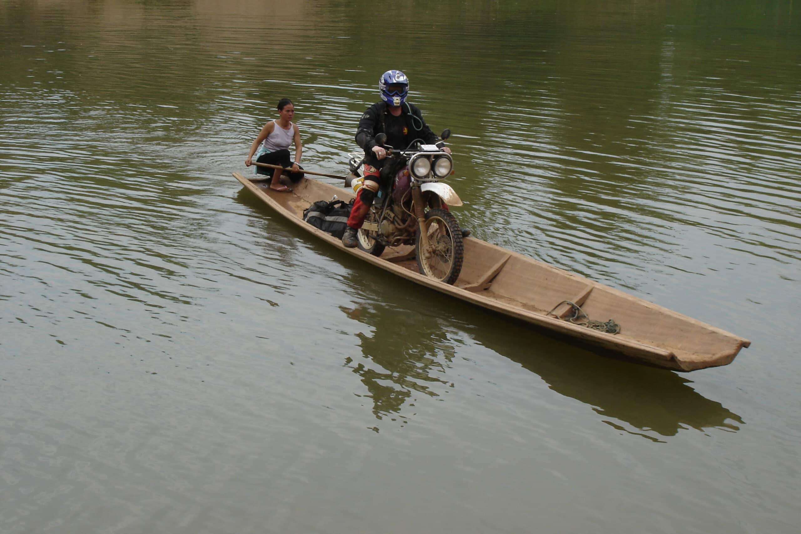 A motorbike rider on a canoe while on the Ho Chi Minh Trail in Laos