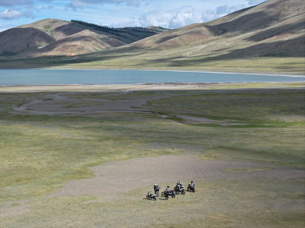 Explore Indochina riders take a break near Zuun Nuur Lake while on a Mongolia motorcycle tour