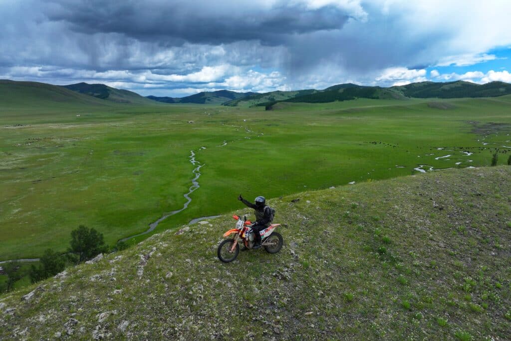 An Explore Indochina rider enjoying verdant steppes near Tsetserleg on his Mongolia motorcycle tour