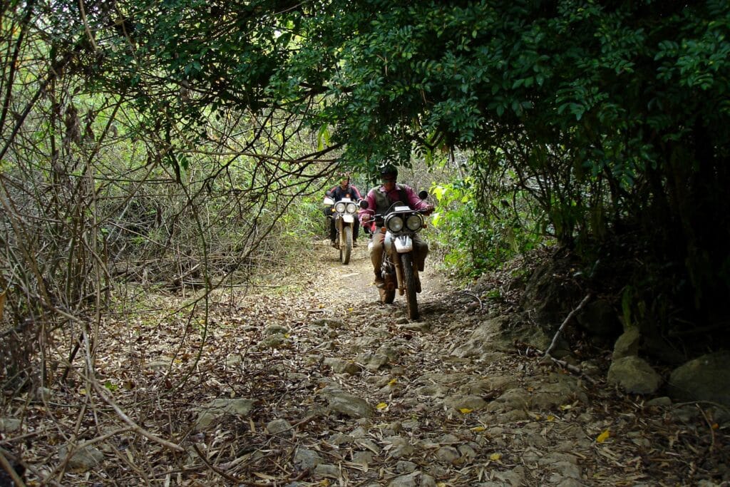Riding original cobblestones of the Ho Chi Minh Trail Laos in the Chokes during on an Explore Indochina motorbike tour