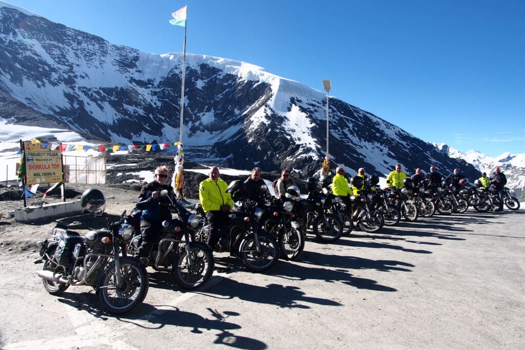Explore Indochina motorcycle tour riders at the top of the Shinkulu Pass in the Himalayas