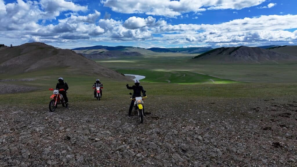 Explore Indochina riders enjoying verdant steppes near Lake Khovsgol on his Mongolia motorcycle tour