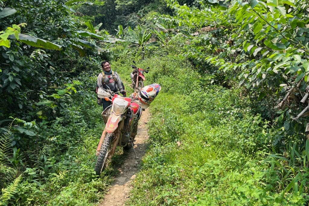 An Explore Indochina rider enjoys single tracks while on a motorbike tour of the Ho Chi Minh Trail in Laos
