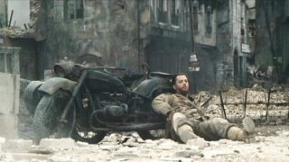 Tom Hanks in Saving Private Ryan, leaning against a Ural sidecar